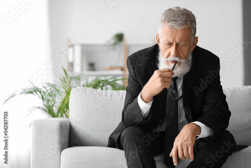 Thoughtful mature man sitti...