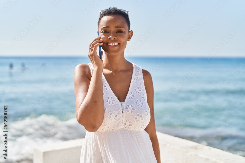 African american woman smiling confident talking on the smartphone at seaside African american woman smiling confident talking on the smartphone at seaside