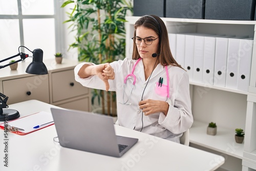 Beautiful doctor woman working on online appointment with angry face  negative sign showing dislike with thumbs down  rejection concept