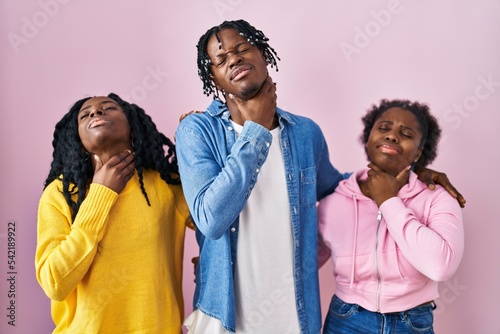 Group of three young black people standing together over pink background touching painful neck, sore throat for flu, clod and infection © Krakenimages.com