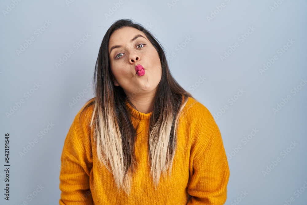 Young hispanic woman standing over isolated background making fish face with lips, crazy and comical gesture. funny expression. Young hispanic woman standing over isolated background making fish face with lips, crazy and comical gesture. funny expression.