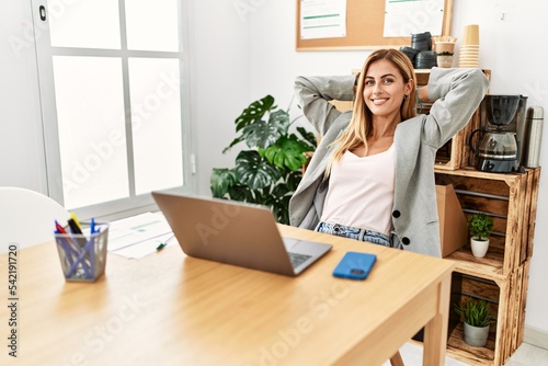 Young caucasian businesswoman relaxed with hands on head at the office.