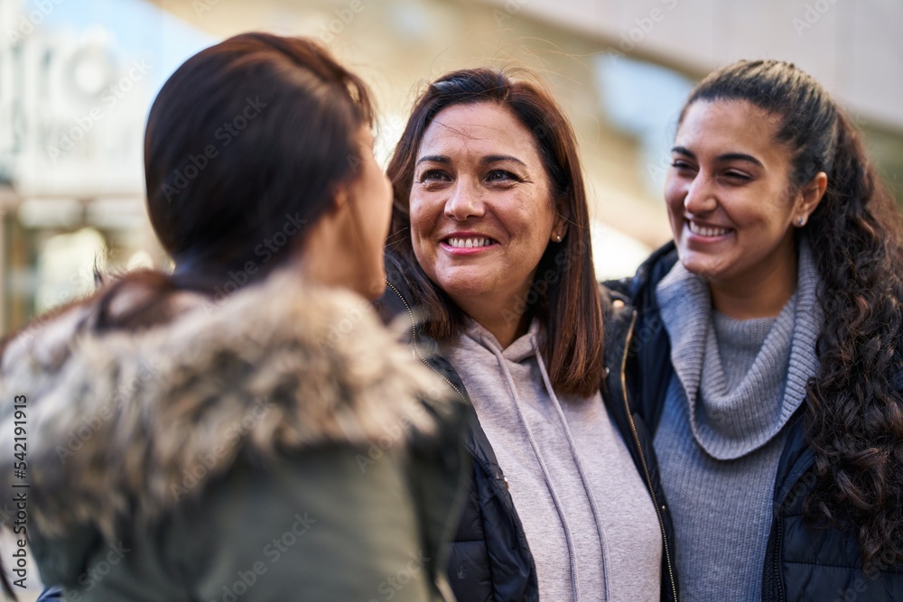Fototapeta premium Three woman mother and daughters standing together at street