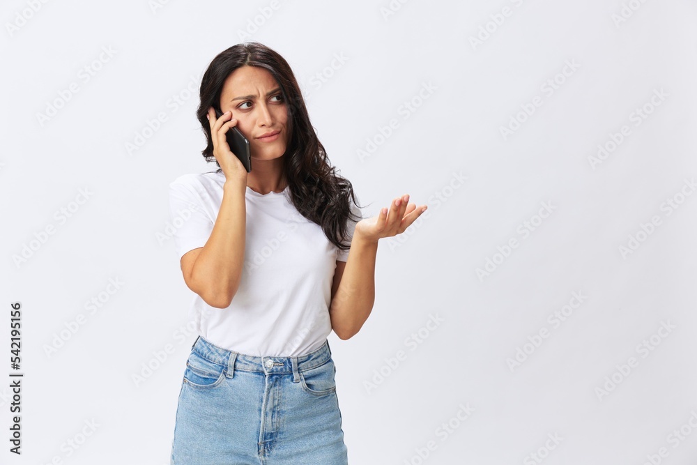 Woman blogger with a phone in her hands photo content, video call, selfie smile with teeth in a white t-shirt on a white background, copy space, emotions and gestures signals Woman blogger with a phone in her hands photo content, video call, selfie smile with teeth in a white t-shirt on a white background, copy space, emotions and gestures signals
