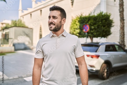 Young hispanic man smiling confident walking at street