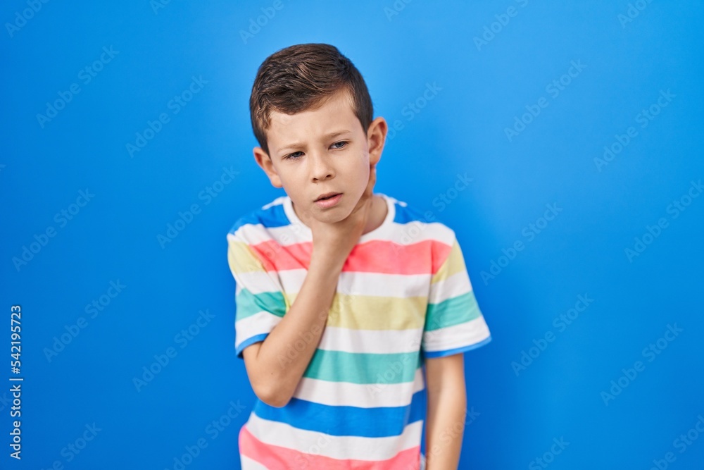 Young caucasian kid standing over blue background touching painful neck, sore throat for flu, clod and infection Young caucasian kid standing over blue background touching painful neck, sore throat for flu, clod and infection