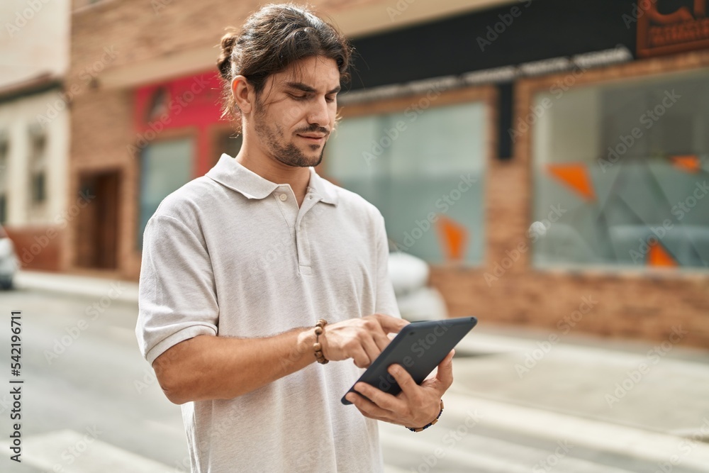 Young hispanic man using touchpad at street Young hispanic man using touchpad at street