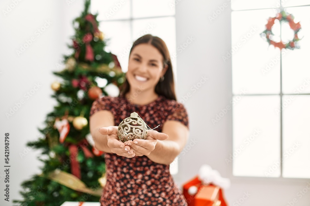 Young beautiful hispanic woman smiling confident holding christmas ball at home Young beautiful hispanic woman smiling confident holding christmas ball at home