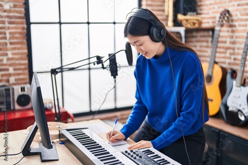 Canvas Print Chinese woman musician composing song at music studio