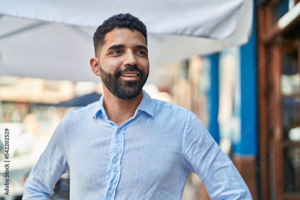 Young arab man smiling confident looking to the side at street Young arab man smiling confident looking to the side at street