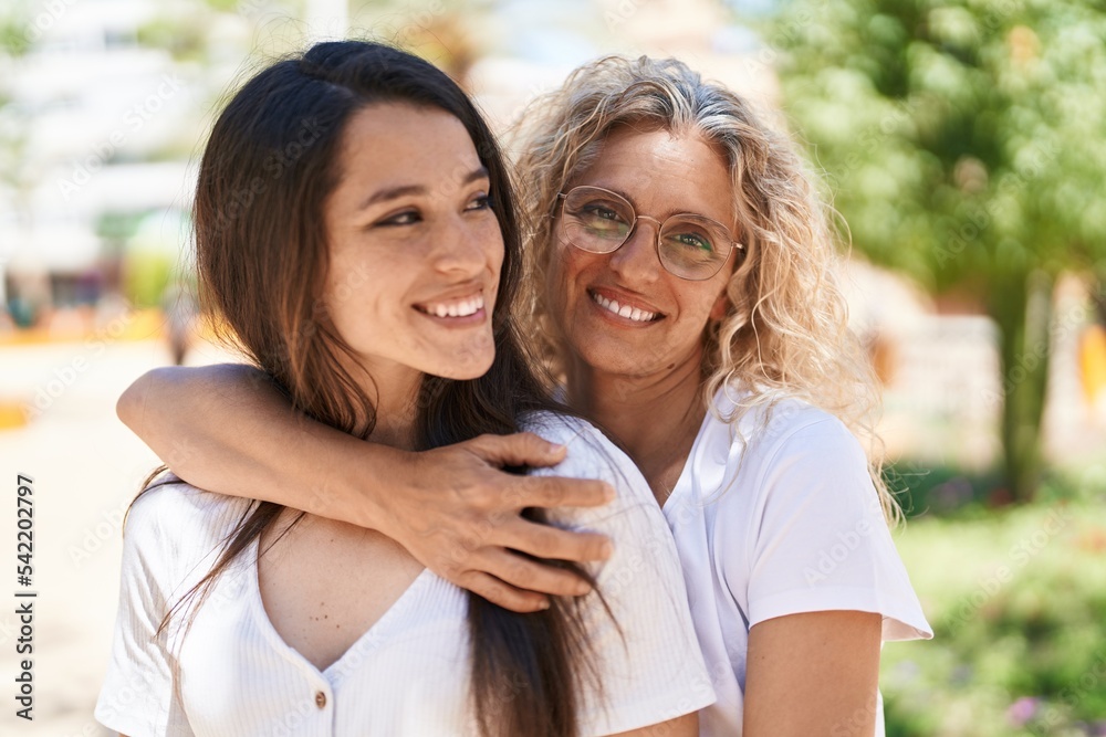 Two women mother and daughter hugging each other at park Two women mother and daughter hugging each other at park