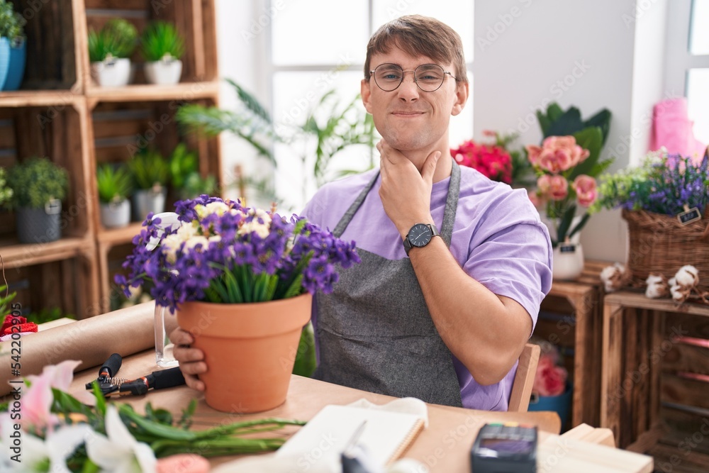 Caucasian blond man working at florist shop touching painful neck, sore throat for flu, clod and infection
