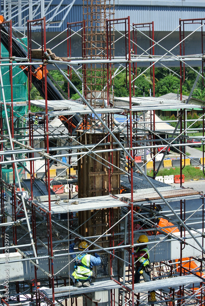Fototapeta premium SERDANG, MALAYSIA -MAY 13, 2016: Construction workers working at the construction site at Serdang, Malaysia during daytime. They are wearing proper safety gear so ensure they are safe working. 