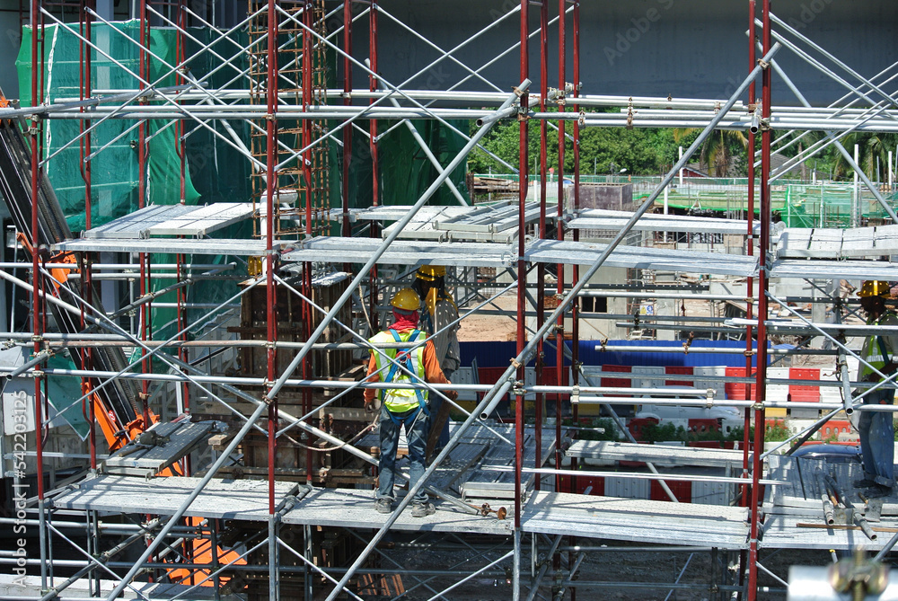 Fototapeta premium SERDANG, MALAYSIA -MAY 13, 2016: Construction workers working at the construction site at Serdang, Malaysia during daytime. They are wearing proper safety gear so ensure they are safe working.