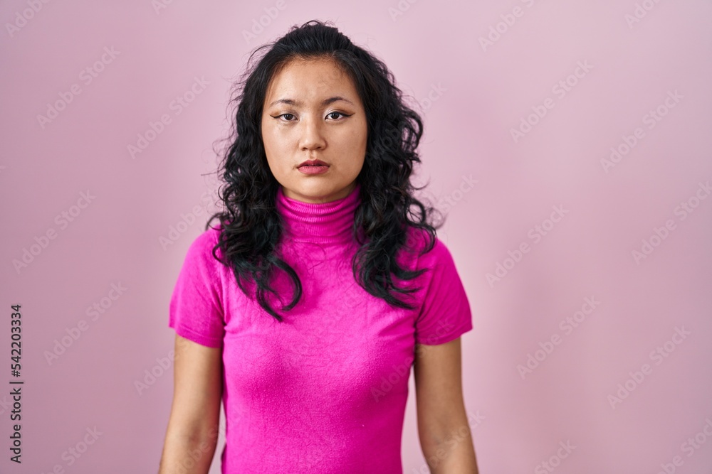 Young asian woman standing over pink background looking sleepy and tired, exhausted for fatigue and hangover, lazy eyes in the morning. Young asian woman standing over pink background looking sleepy and tired, exhausted for fatigue and hangover, lazy eyes in the morning.