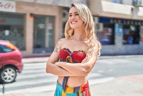 Young blonde woman standing with arms crossed gesture at street © Krakenimages.com