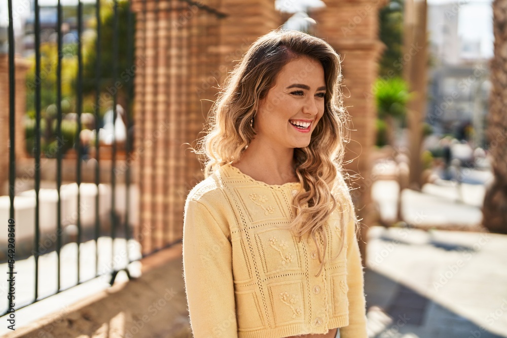 Fototapeta premium Young woman smiling confident looking to the side at street