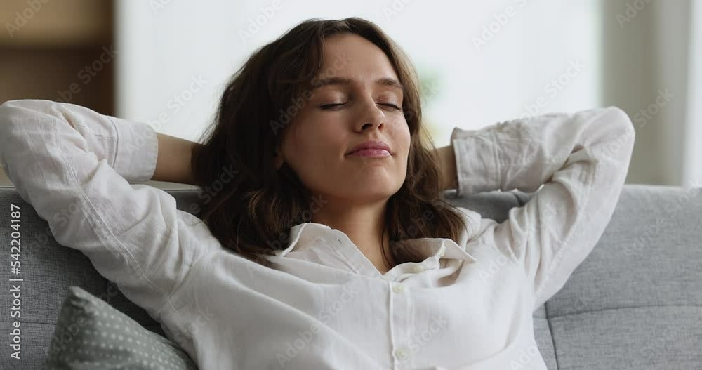 Close up shot attractive young 30s woman relaxing on cozy couch feels carefree, looks happy, enjoy stress-free weekend at modern home. Fresh air, climate control, homeowner or tenant portrait concept Close up shot attractive young 30s woman relaxing on cozy couch feels carefree, looks happy, enjoy stress-free weekend at modern home. Fresh air, climate control, homeowner or tenant portrait concept