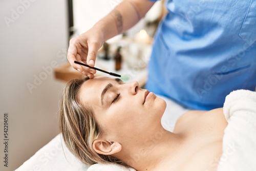 Woman couple having eyebrows treatment at beauty center