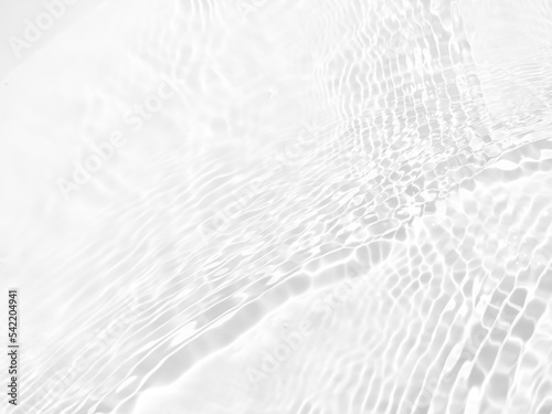Defocus blurred transparent white colored clear calm water surface texture with splash, bubble. Shining purple water ripple background. Surface of water in swimming pool. White bubble water shine.