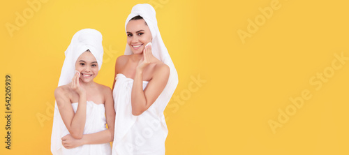 Mother and daughter child banner, copy space, isolated background. beauty day in spa. family spa. mother and teen girl use cotton pads. skincare. taking off makeup.