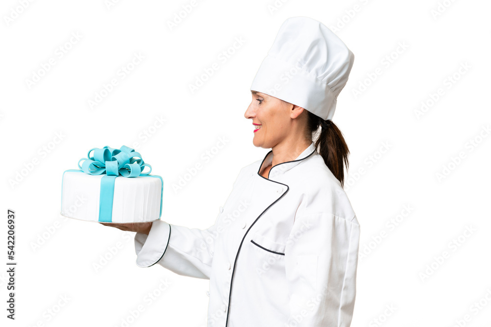 Middle-aged chef caucasian woman with a big cake over isolated background with happy expression Middle-aged chef caucasian woman with a big cake over isolated background with happy expression