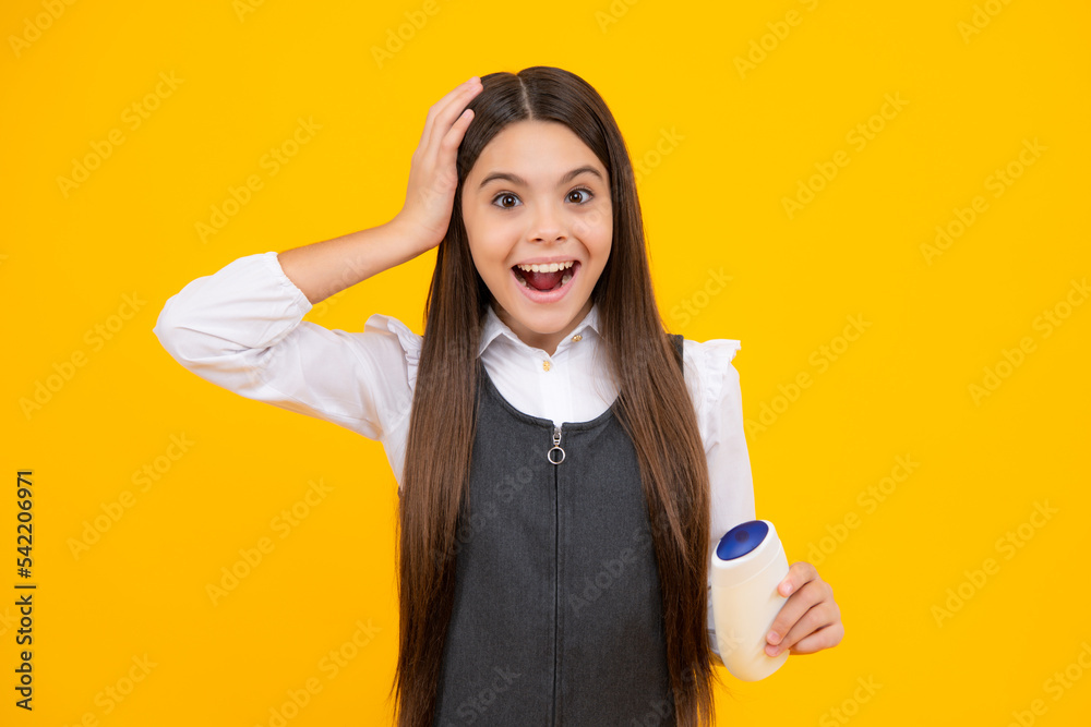 Amazed teen girl. Teenager child girl showing bottle shampoo conditioners or shower gel. Hair cosmetic product. Bottle for advertising mock up copy space. Excited expression, cheerful and glad. Amazed teen girl. Teenager child girl showing bottle shampoo conditioners or shower gel. Hair cosmetic product. Bottle for advertising mock up copy space. Excited expression, cheerful and glad.