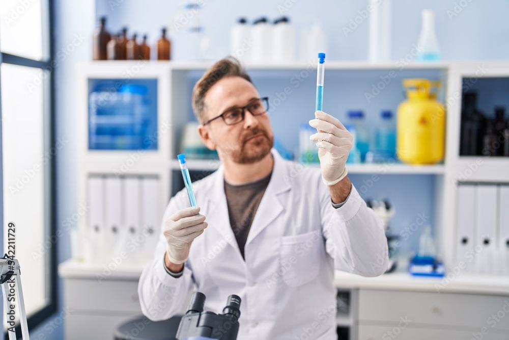 Young caucasian man scientist holding test tubes at laboratory Young caucasian man scientist holding test tubes at laboratory