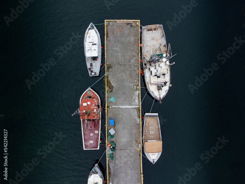 Looking down view of fishing boats tied to a dock on the East coast of Canada in Newfoundland. © Ramon Cliff