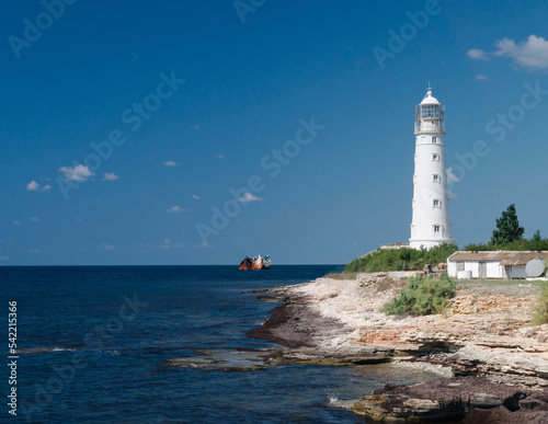 white lighthouse on the seashore. sunken ship near the coast. Crimea, Tarkhankut