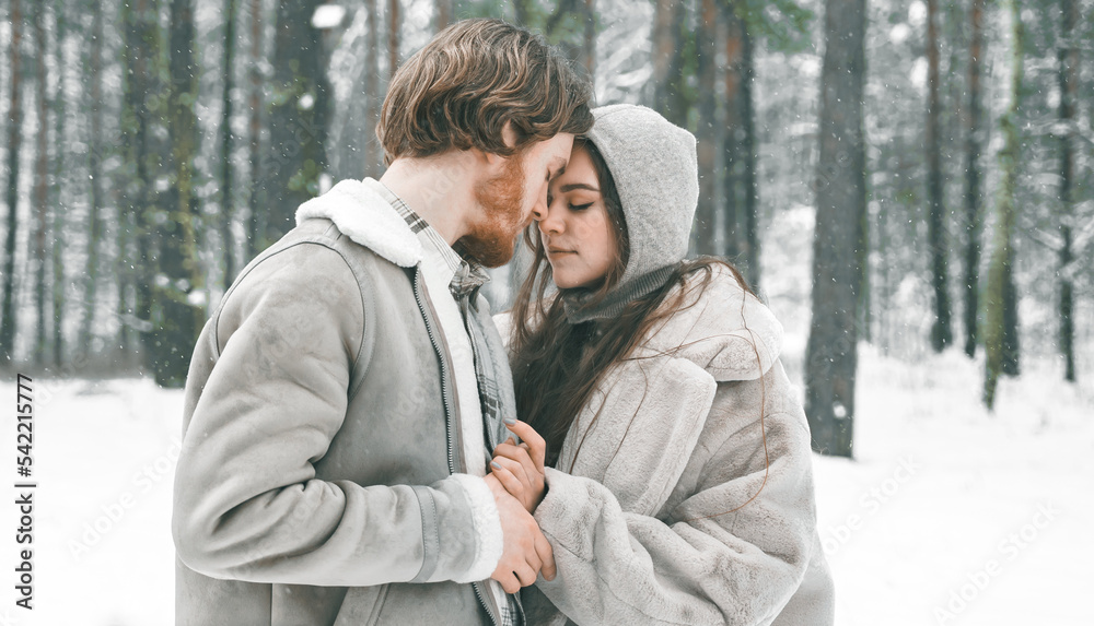 Love romantic young couple. Guy hugging kissing girl in snowy winter forest. Walking,having fun in trees, laughing. Stylish clothes,fur coat,jacket,woolen shawl. Snow lovestory. Romantic date,weekend Love romantic young couple. Guy hugging kissing girl in snowy winter forest. Walking,having fun in trees, laughing. Stylish clothes,fur coat,jacket,woolen shawl. Snow lovestory. Romantic date,weekend