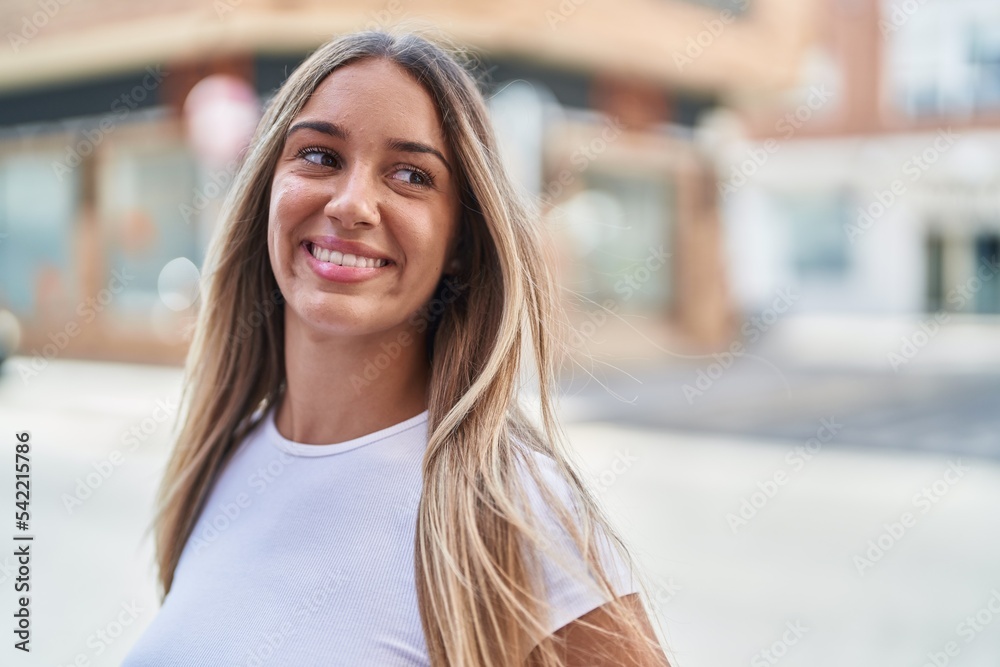Young beautiful hispanic woman smiling confident looking to the side at street Young beautiful hispanic woman smiling confident looking to the side at street