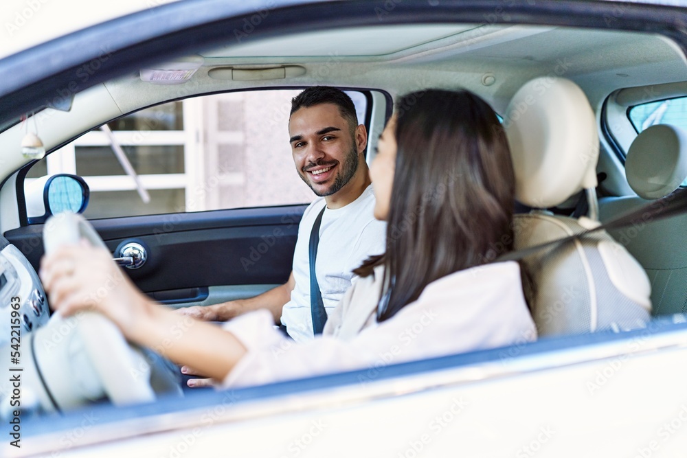 Young hispanic couple smiling happy driving car at the city. Young hispanic couple smiling happy driving car at the city.