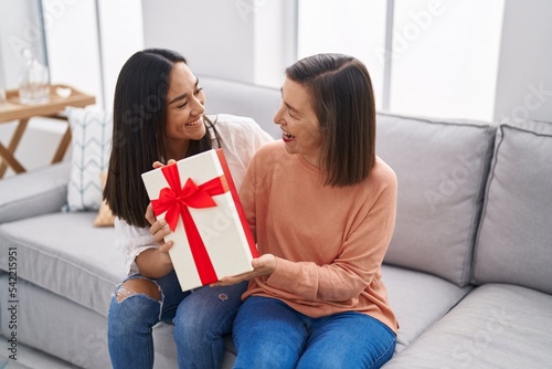 Two women mother and daughter surprise with gift at home