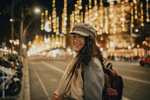 Photography Woman smiling in the middle of a street decorated with Christmas lights