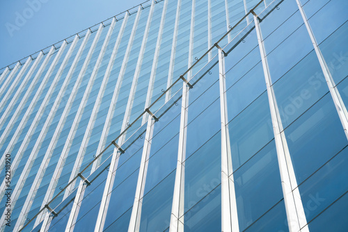 close-up soft light pattern glass wall facade exterior architecture building reflection blue sky clean environment background. modern business office concept smart city backdrop cover minimal design.
