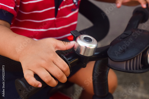 close up of kid hand holding a handle bar and bicycle bell