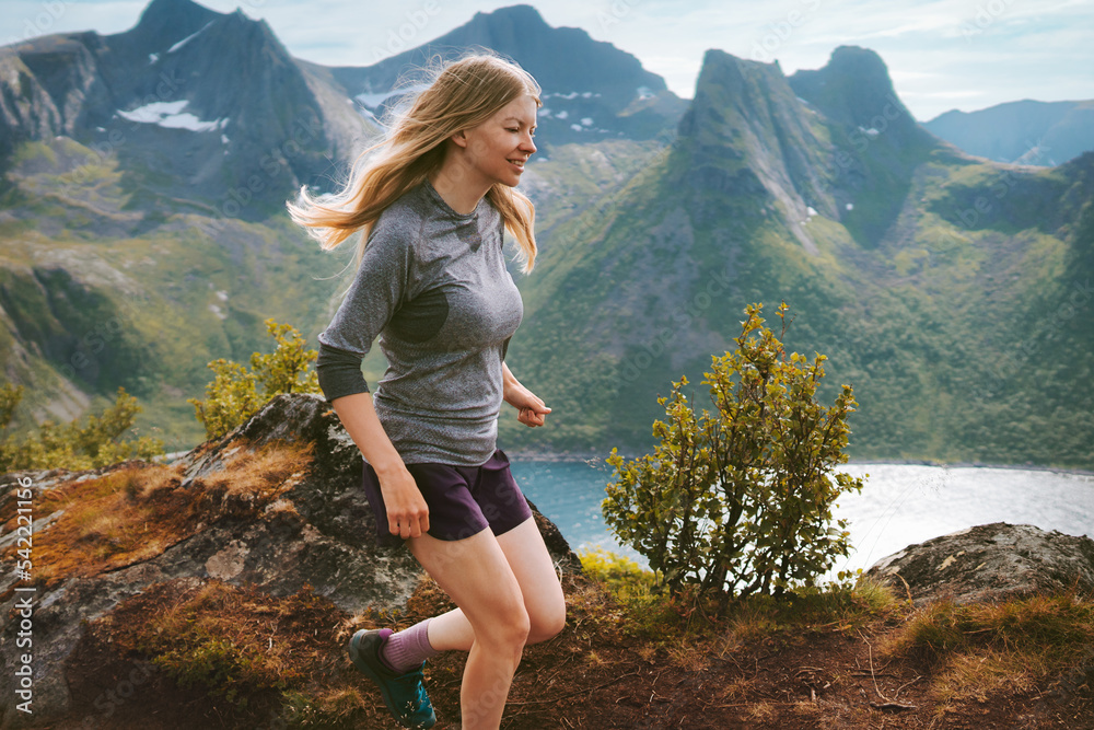 Active woman running in mountains of Norway outdoor travel adventure hiking healthy lifestyle trip motivation freedom concept Senja island landscape