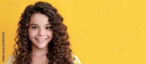 happy child with long curly hair and perfect skin, frizzy. Child face, horizontal poster, teenager girl isolated portrait, banner with copy space.