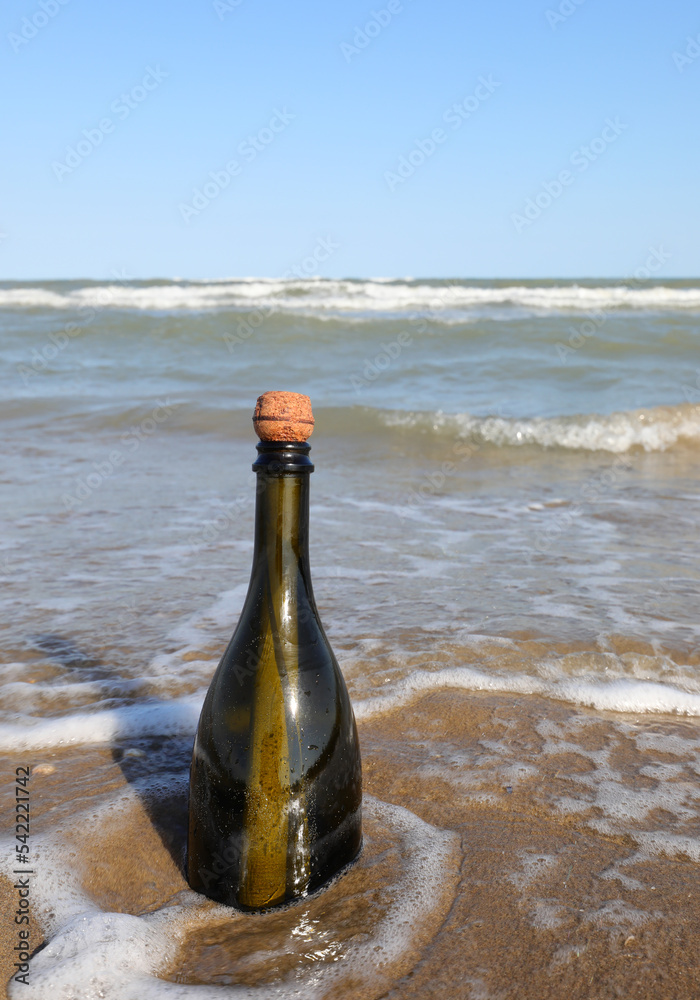 beached green glass bottle with a message inside on the foreshore beached green glass bottle with a message inside on the foreshore