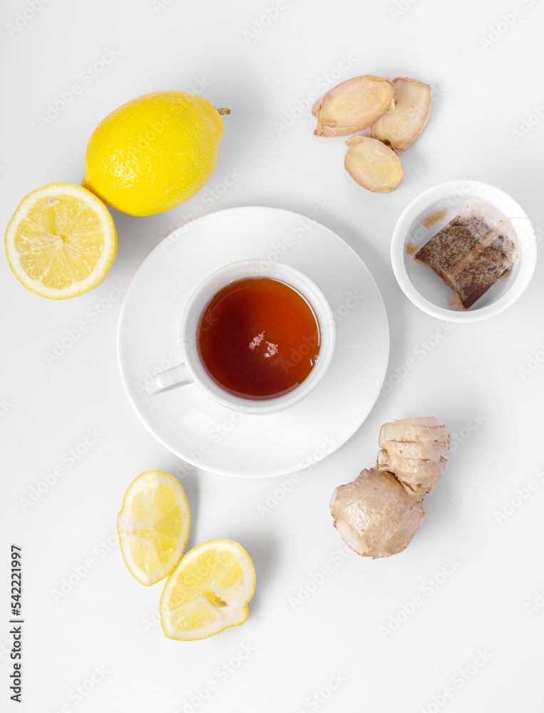 A cup of fresh tea with lemon and ginger. White background, isolated white. Top view. Copy space.