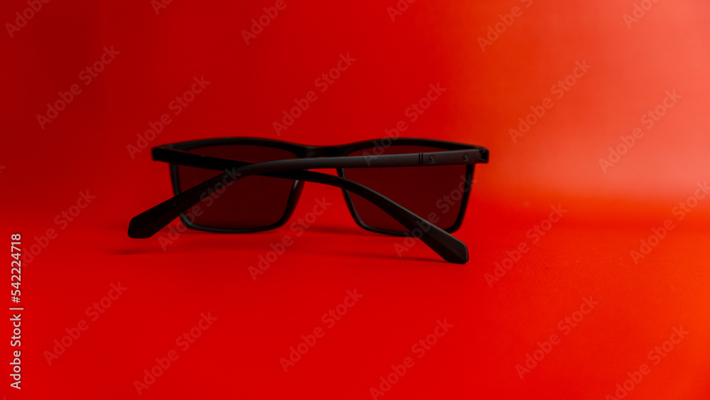 Black sunglasses on red background Black sunglasses on red background