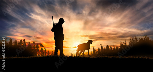 Tableau sur toile hunter with dog at sunset