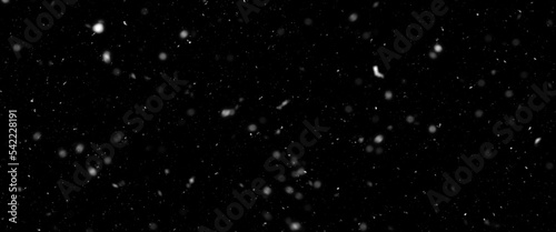 Falling snow isolated on black background. Falling snow at night. Bokeh lights on black background, flying snowflakes in the air. Winter weather. Overlay texture. 