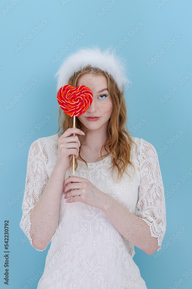 Closeup of woman's holding a heart lolipop in front of her Closeup of woman's holding a heart lolipop in front of her