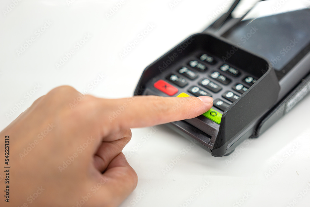 Person hand is pressing the enter button to confirm payment transaction on the credit card reader device. Business and technology action scene photo, selective focus. Person hand is pressing the enter button to confirm payment transaction on the credit card reader device. Business and technology action scene photo, selective focus.