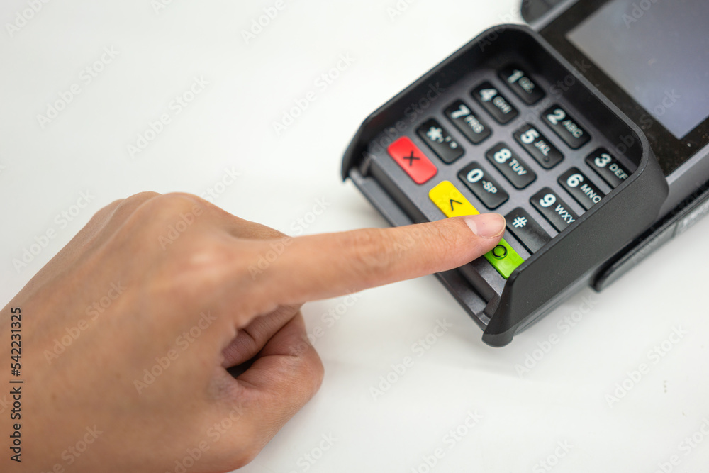Person hand is pressing the enter button to confirm payment transaction on the credit card reader device. Business and technology action scene photo, selective focus. Person hand is pressing the enter button to confirm payment transaction on the credit card reader device. Business and technology action scene photo, selective focus.