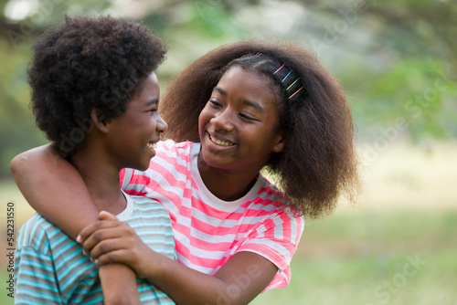 Two African American boy and girl playing and hugging together outdoor. Happy two afro children playing together in the park. Happy black people concept
