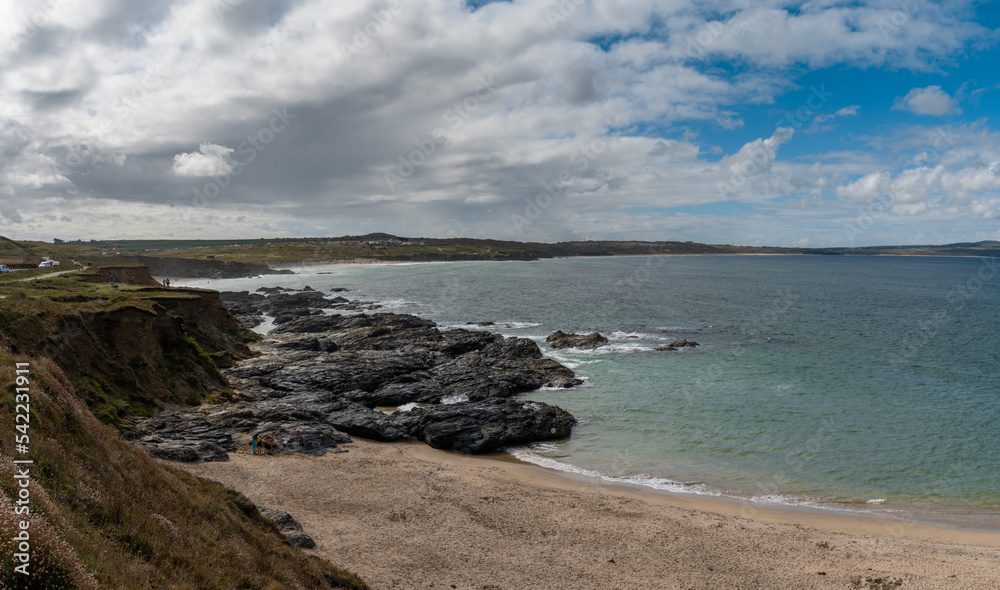 the beach at Gwithian with tropical turquoise ocean water and the Cornwall Coast behind