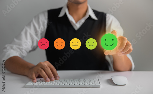 Businessman pressing face emoticon rating on virtual touch screen to service experience. Customer service and Satisfaction concept.